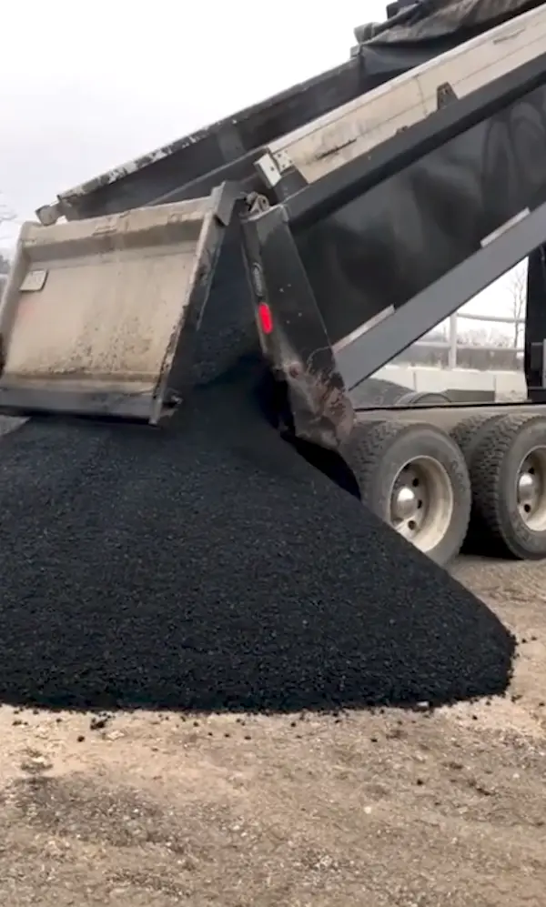 Camion déversant de l'asphalte recyclé lors de travaux de pavage