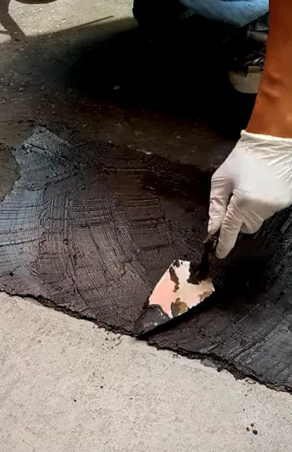 Precise asphalt driveway sealing along the edges of a residential property. Quality driveway sealing services prevent edge cracking and improve curb appeal.