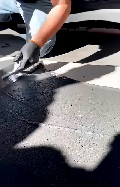Hands-on asphalt driveway crack repair using a professional-grade filler. Targeted asphalt driveway repair helps prevent water infiltration and further damage.