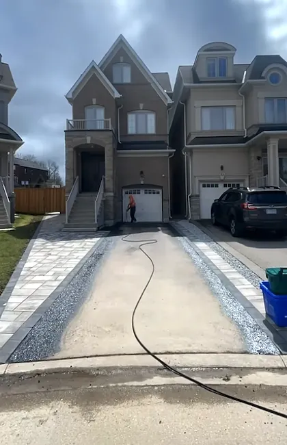 A professional from an asphalt driveway sealing company preparing a large residential entrance. This essential step ensures the driveway sealant adheres perfectly for a durable result.